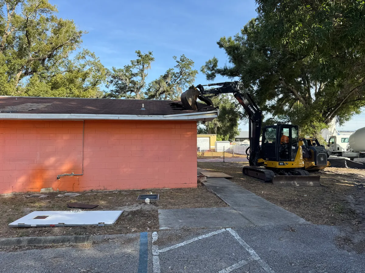 Excavator performing building demolition